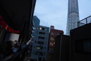 a couple kissing on a building in the city at Geisha Expelience Stay in Tokyo
