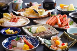 Kinosaki Yamamotoya في تويوكا: طاولة مع أطباق بأنواع مختلفة من الطعام