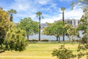 un parque con palmeras y un cuerpo de agua en Vintage 2BR CBD Apartment w/River View en Perth