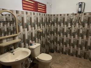 a bathroom with a toilet and a sink at Walawa Blue Sapphire in Udawalawe