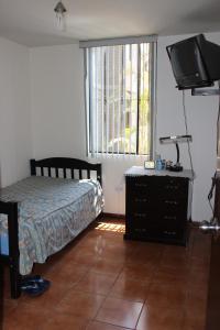 1 dormitorio con 1 cama y TV de pantalla plana en Hermoso departamento de dos dormitorios en el primer piso, en Lima