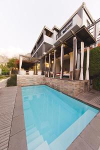 a swimming pool in front of a house at Kensington Place in Cape Town