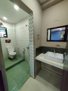 y baño con lavabo y aseo. en Hotel Sai Jagannath Bhubaneswar, en Bhubaneshwar