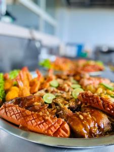 un plato de comida con carne y verduras en una mesa en Ajith Putha Grand, en Madampe