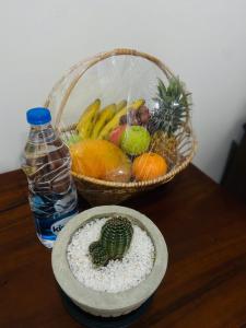 a table with two baskets of fruit and a bottle of water at Ajith Putha Grand in Madampe