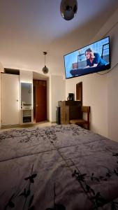 ein Schlafzimmer mit einem Bett und einem TV an der Wand in der Unterkunft Castellares La Puebla Habitación y estudio en el centro in Ayacucho