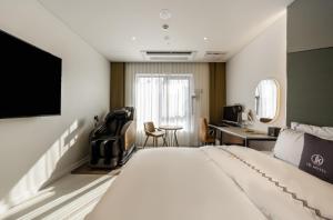 a hotel room with a bed and a desk at Gimpo JK Hotel in Gimpo