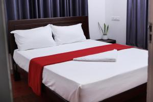 1 dormitorio con 2 camas con sábanas blancas y rojas en Bellfields Homestay, en Meenangadi