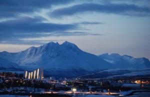 a city with snow capped mountains in the background at Polar Arctic View - Free Parking! in Tromsø