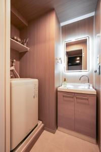 baño pequeño con fregadero y nevera en Apartment Hotel 11 Dotonbori II en Osaka