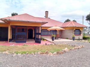 una casa con tetto rosso e patio di Esniko Villa a Narok