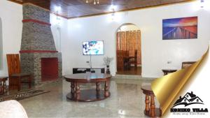 a living room with a table and a fireplace at Esniko Villa in Narok
