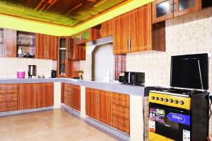 a kitchen with wooden cabinets and a stove top oven at Esniko Villa in Narok