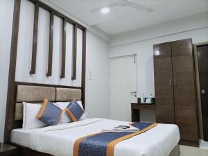 a bedroom with a large bed with blue pillows at Hotel Zain Grande in Chennai