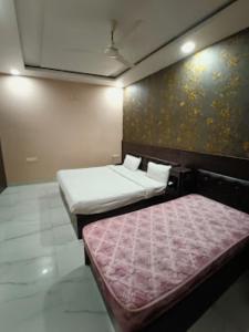 Pokój z dwoma łóżkami i ścianą z w obiekcie Hotel VK INN Prayagraj w mieście Prayagraj