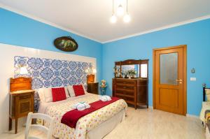 a bedroom with a bed and a dresser and a mirror at Casa delle Zammare Fronte mare centro storico in Riposto