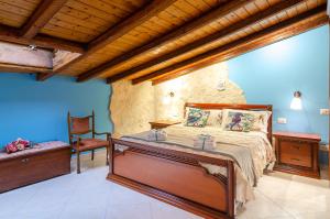una camera con un grande letto e una sedia di Casa delle Zammare Fronte mare centro storico a Riposto