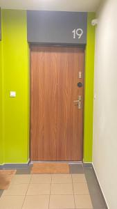 a large wooden door in a room with green walls at Apartament Złocień in Kraków