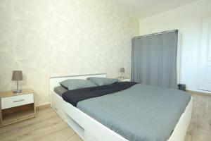 een slaapkamer met een groot bed met blauwe lakens bij Élégant appartement bord de Seine in Montereau-faut-Yonne