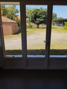 una puerta de cristal abierta con vistas a un patio en Chez Christophe, en Maubourguet