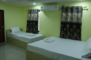 two beds in a room with curtains andacers at Hotel J B L in kolkata
