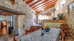 a dining room with a table and a stone wall at Molino Higueral Villanueva del Trabuco by Ruralidays in Villanueva del Trabuco