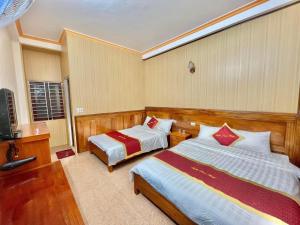 Cette chambre comprend deux lits et une télévision. dans l'établissement Tuyên Thoa Hotel, à Sa Pa