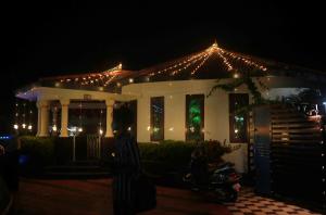 a house with christmas lights and a motorcycle in front of it at GB 25 Cottage in Trivandrum