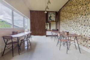 Jepun Guest House في ماتارام: غرفة طعام مع طاولات وكراسي وجدار من الطوب