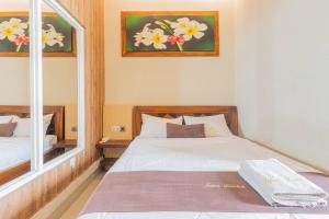a bedroom with a bed and a mirror at Jepun Guest House in Mataram