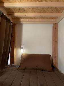 1 dormitorio con 1 cama con techo de madera en もりぞう, en Tomioka