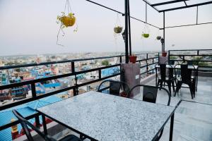 a restaurant with tables and chairs on a balcony at MOON NIGHT GUEST HOUSE in Jodhpur