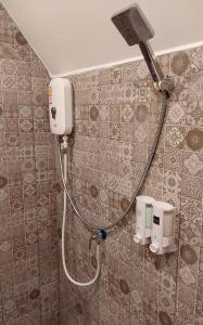 a shower in a bathroom with a hose on the wall at เรินนายหัว by KOYAD 