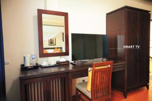 a wooden desk with a mirror and a wooden chair at Harmony Patong Hotel in Patong Beach