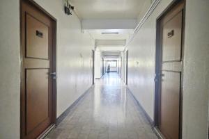 an empty hallway in an office building with two doors at Green Apartment Kaset in Bangkok