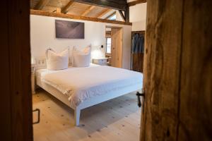 a bedroom with a bed with white sheets and pillows at Ferienwohnung Lexar Hüs Oberstdorf in Oberstdorf