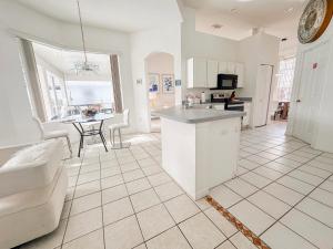 - une cuisine et un salon avec un comptoir et une table dans l'établissement Grand Exclusive 4BR Pool Home near Disney Parks, à Davenport