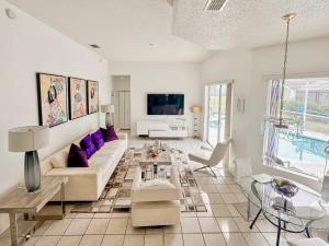a living room with a couch and a table at Grand Exclusive 4BR Pool Home near Disney Parks in Davenport