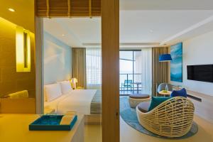 um quarto de hotel com uma cama e uma sala de estar em Holiday Inn Pattaya, an IHG Hotel em Pattaya Central