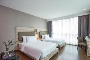 Postel nebo postele na pokoji v ubytování Adelphi Suites Bangkok + 37 fotografií