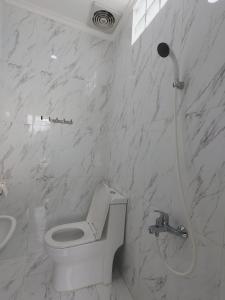 une salle de bain blanche avec toilettes et douche dans l'établissement Griya Bausasran, à Sentool