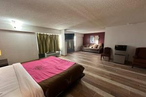 a bedroom with a large bed with a pink blanket at River Valley Inn and Suites I-40 in Fort Smith