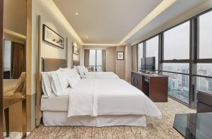 um quarto de hotel com uma cama grande e uma televisão em The Westin Ningbo em Ningbo
