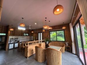 an open kitchen with wooden walls and tables and chairs at OMTARA RETREAT in Yen Bai