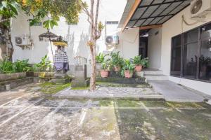 a house with potted plants outside of it at Penginapan Asri in Mataram