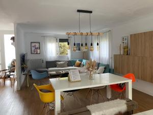 een woonkamer met een witte tafel en gele stoelen bij La villa Garonne avec piscine in Toulouse