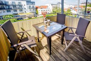een balkon met een glazen tafel en 2 stoelen bij Admiral in Warnemünde