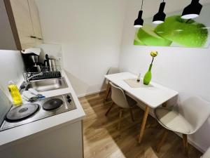 a small kitchen with a table and a white counter top at Ferienwohnung beach, ca 150 m zum Strand in Warnemünde