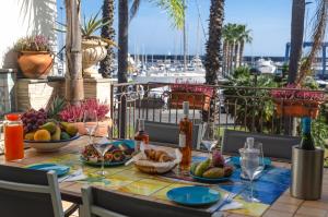 a table with fruit on a balcony with a view of a harbor at Casa delle Zammare Fronte mare centro storico in Riposto