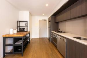 cocina con encimera, fregadero y microondas en Cozy 1Bed Unit in leafy Carlton - 10 mins from CBD, en Melbourne